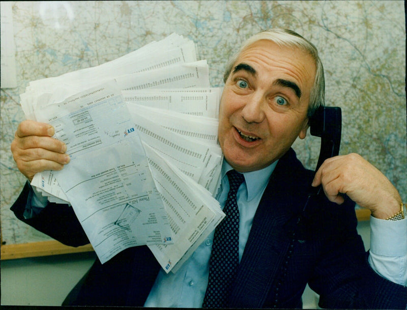 Terry Wood holds his phone bill from B.T., stunned by the size and expense. - Vintage Photograph