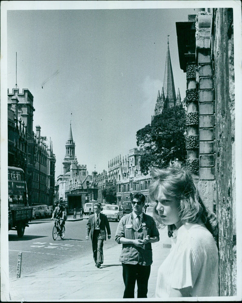 A woman stands in front of a row of buildings on Oxford Street. - Vintage Photograph