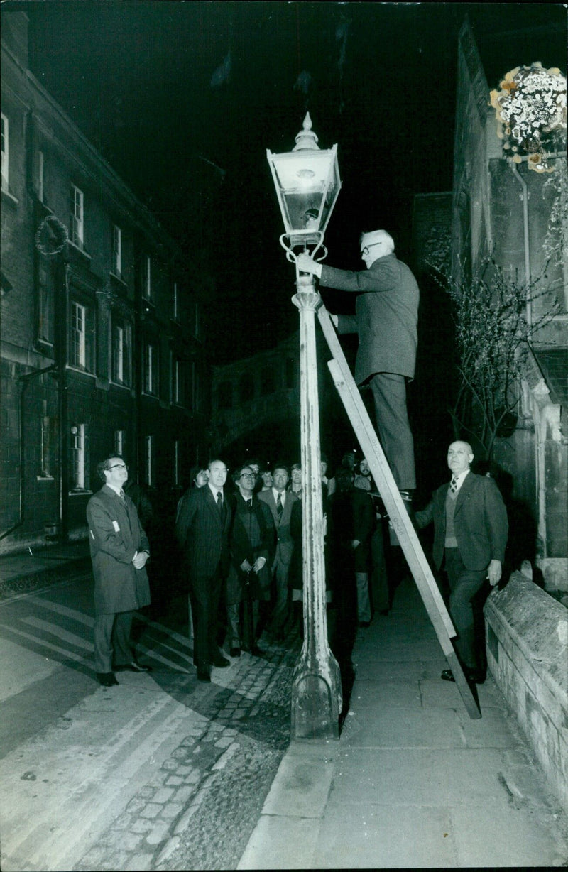 Fred Kane, Chairman of the Oxford Council Highways Committee, turns off the last gas street lamp in Oxford, England. - Vintage Photograph