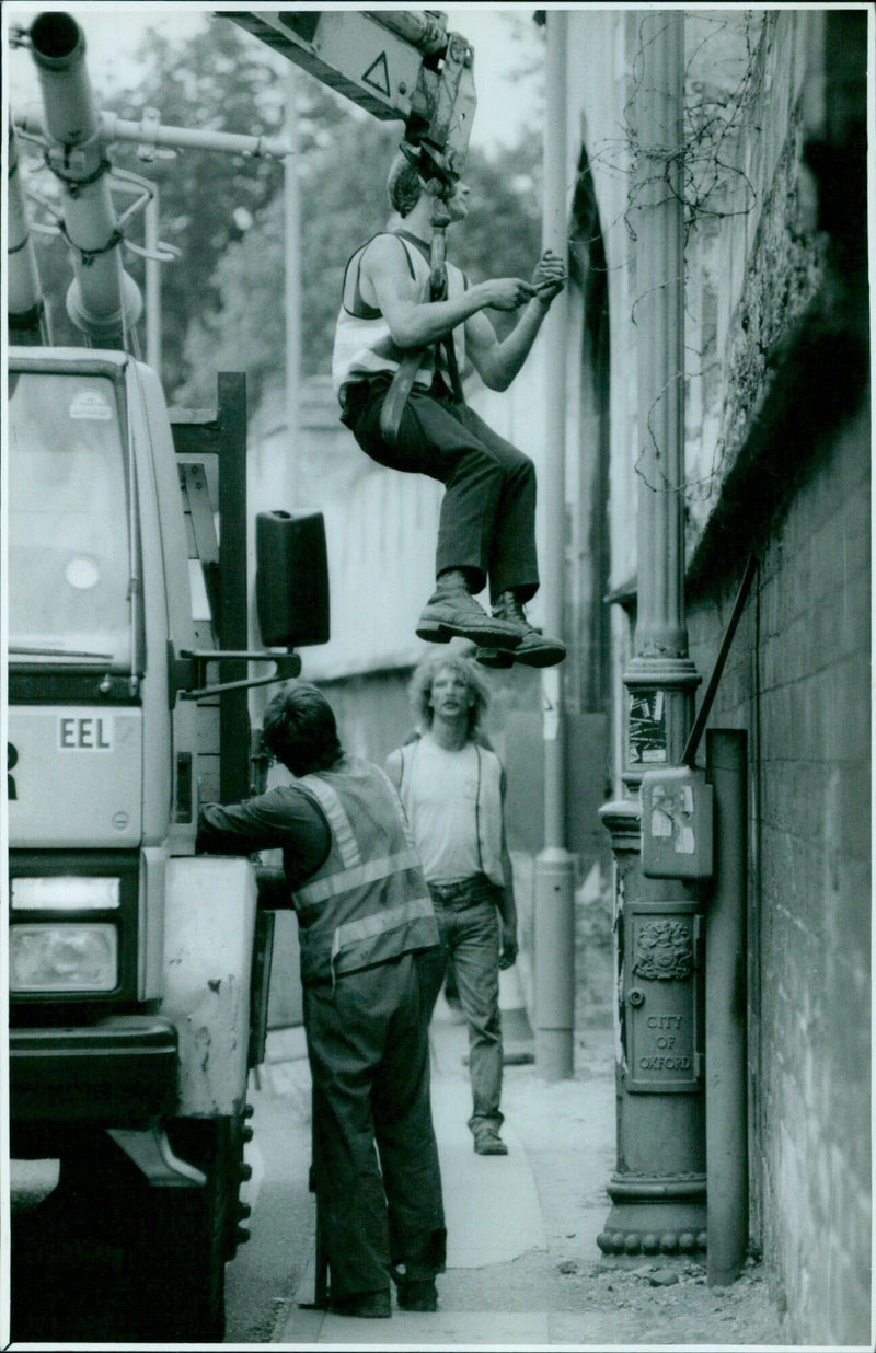 Workmen removing old lamp posts on Longwall Street in Oxford, to be replaced by modern ones. - Vintage Photograph