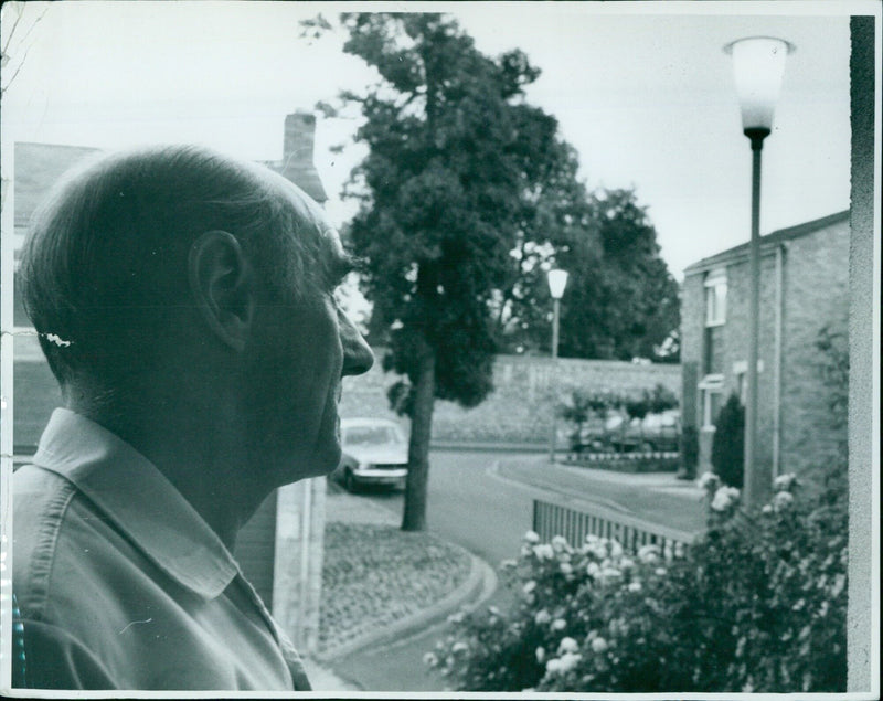 Man looking at 24-hour street lamps. - Vintage Photograph