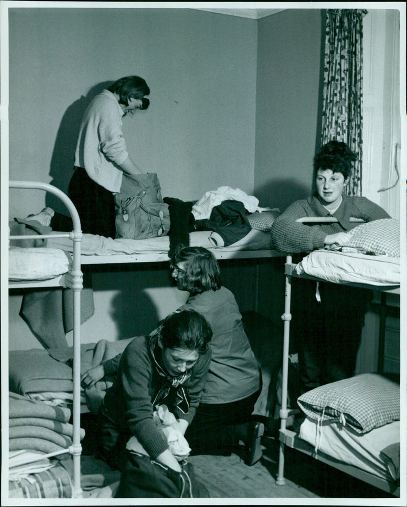 Girls make their beds in a youth hostel on Good Friday. - Vintage Photograph