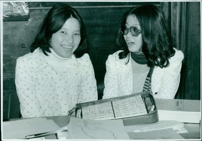 Two young women provide information on club activities at a Freshers Fair at the Examination Schools in Oxford. - Vintage Photograph