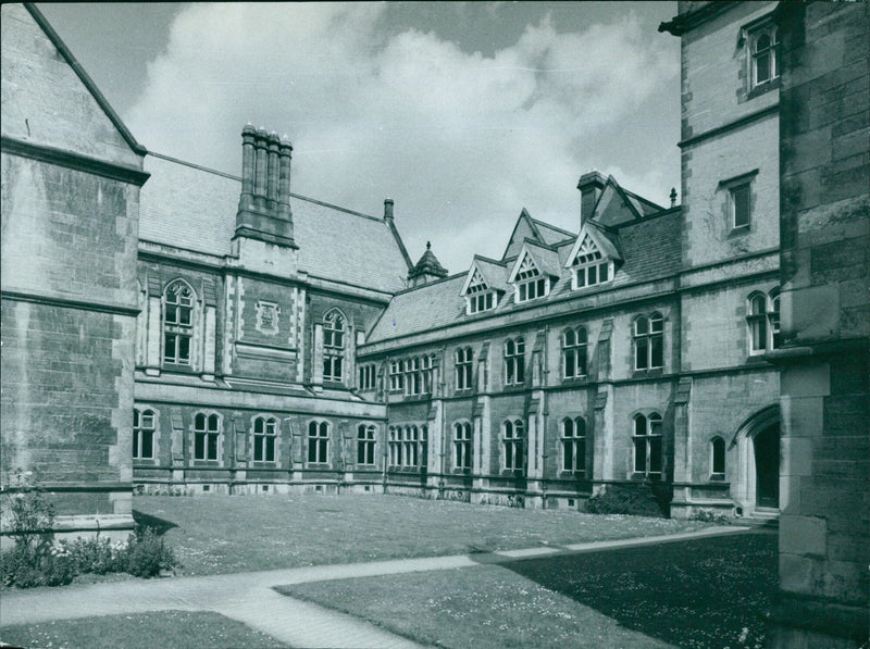 Students and faculty walking in the courtyard of the Oxford University colleges in Manchester, England. - Vintage Photograph