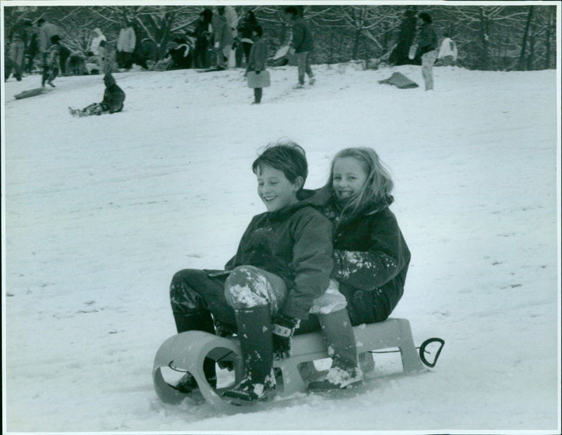 Two siblings, Gavin Hudson, 12, and Emma Hudson, 10, having fun in the snow at South Parks in Oxford. - Vintage Photograph