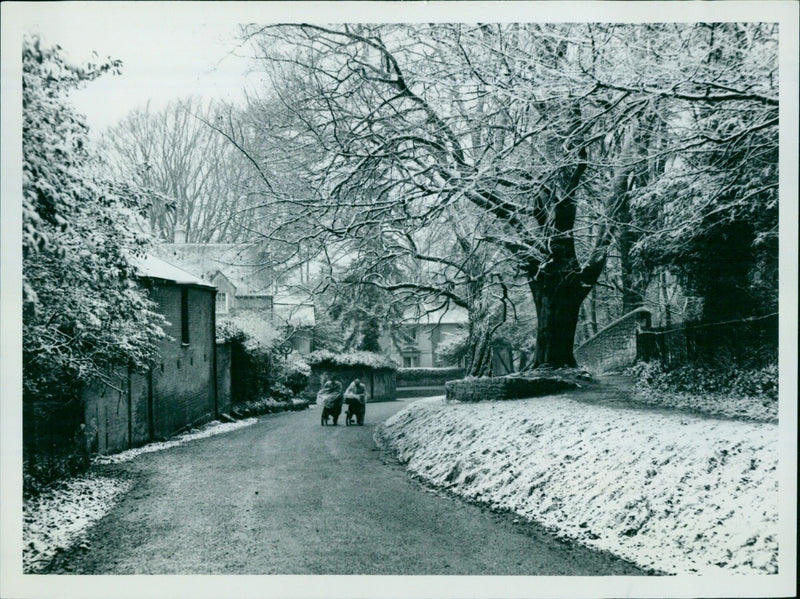 A man trudges through the snowy streets of Oxford, England, on February 1, 1956. - Vintage Photograph