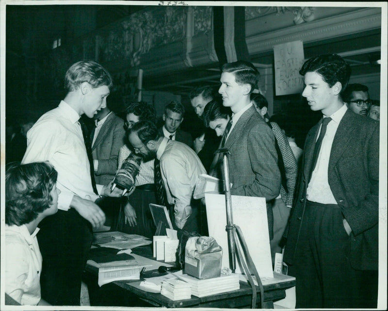 Miss Jennifer Dawson and Mr. D. Sugden answer questions about the Oxford University Mountaineering Club at a Freshmen's Fair in the Town Hall. - Vintage Photograph