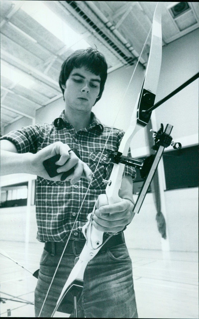 Mark Hopwood of Balliol adjusts the compensator button on his bow during an Oxford University Archery Club practice. - Vintage Photograph