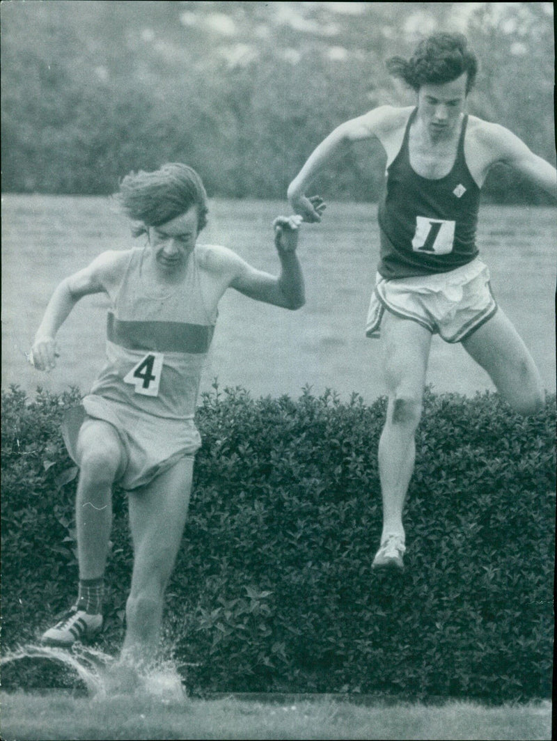 Two university athletes compete in the 3000m steeplechase at Iffley Road Stadium. - Vintage Photograph