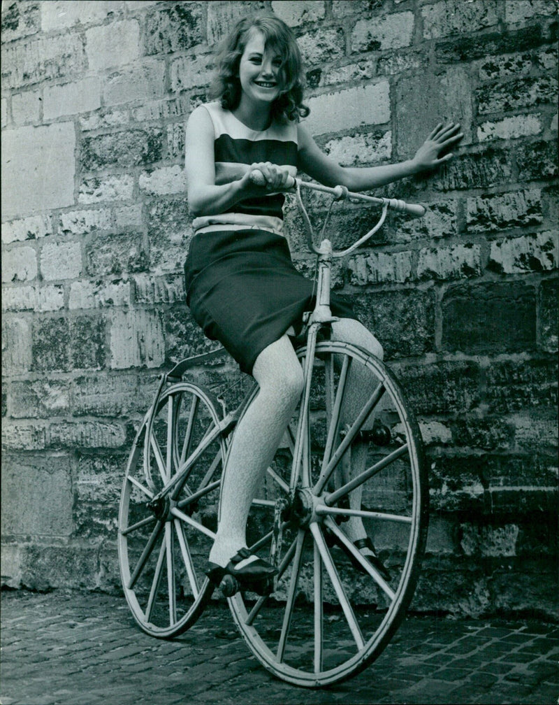 Christine Haunch, 19, takes a spin in a Bone-shaker, a contraption used in the upcoming musical of the same name at the Oxford University Experimental Theatre Club. - Vintage Photograph