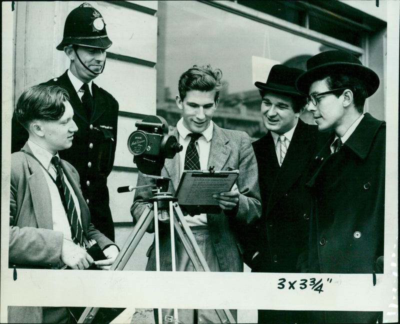 Actors and crew check the script during a film shoot in Oxford. - Vintage Photograph