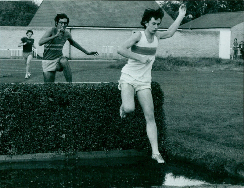 John Taylor of S.E.H. leaps over a water jump in the steeple chase at Iffley Road track. - Vintage Photograph