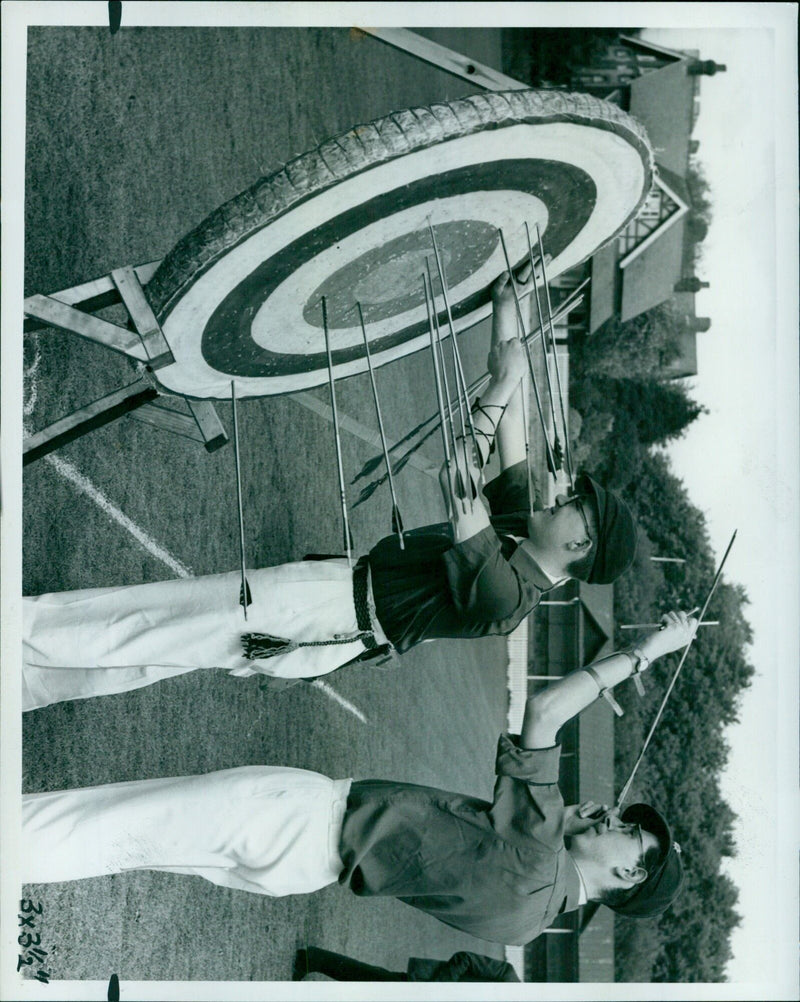 Oxford University Company of Archers President, D. Herbison-Evans, prepares to shoot an arrow during the annual inter-Varsity archery match on the OURFC ground in Iffley Road. - Vintage Photograph