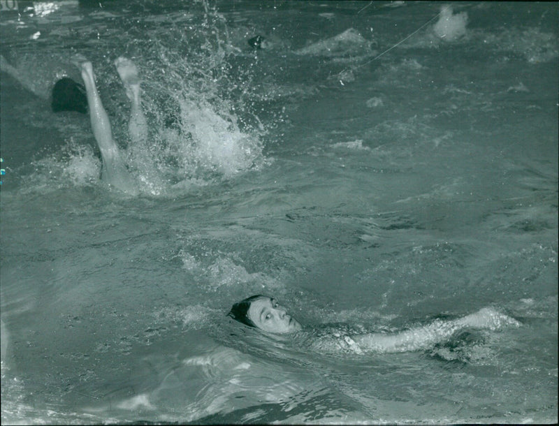 On November 27, 1968, swimmers compete in a 100 yards backstroke race at Oxford University Swimming Club (OUSC) vs. Camp Hill, Birmingham. - Vintage Photograph