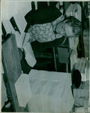 Eleven men in industrial clothing stand beside a water tank at a facility. - Vintage Photograph