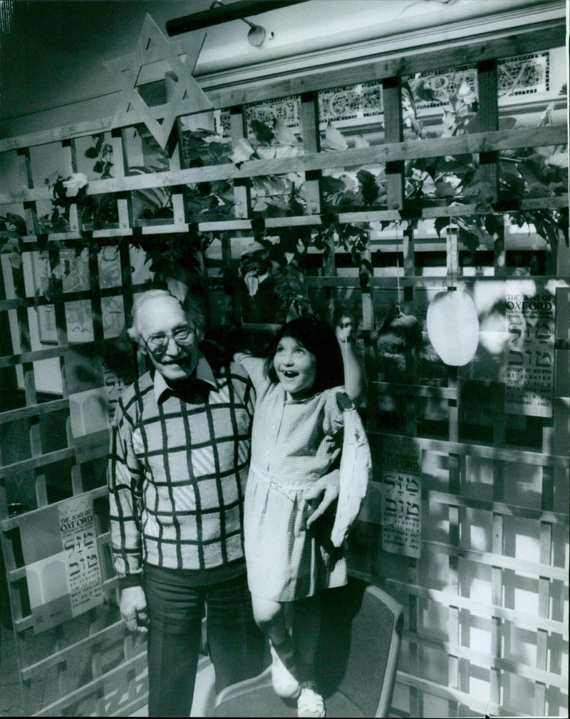 Five-year-old Jennifer Le Tocq hangs fruit at the Jewish Exhibition in Oxford, UK. - Vintage Photograph