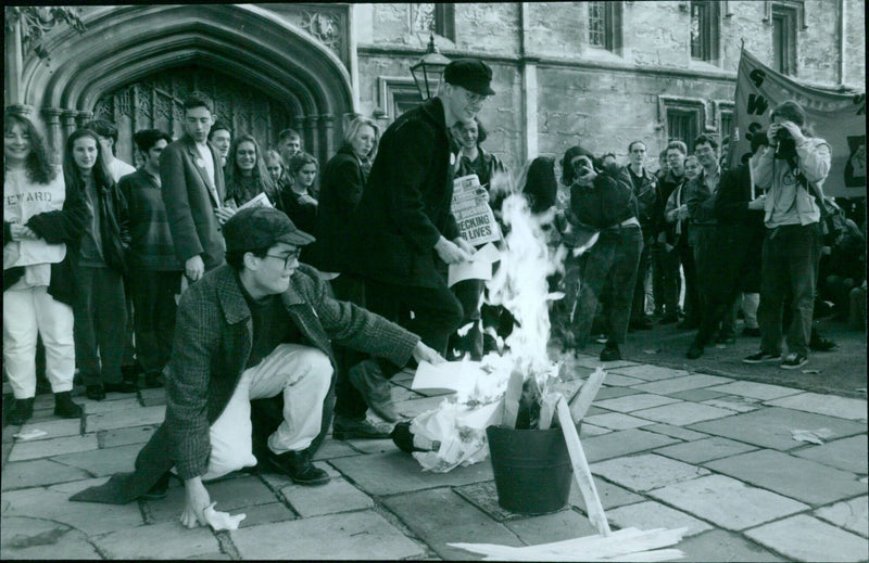 Oxford university students burn their books during a demonstration outside St John's College. - Vintage Photograph