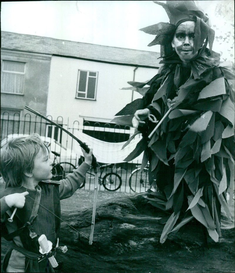 A six-year-old girl dressed as a firebird looks worriedly at five-year-old Jamie Conn dressed as Robin Hood at the 1984 Jericho Community Festival in Oxford. - Vintage Photograph