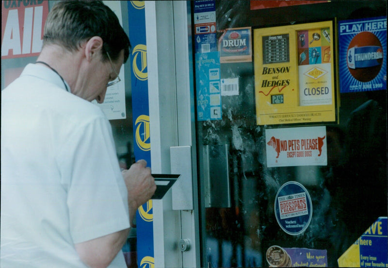 Police investigate a robbery at News Plus in Oxford on June 28, 2000. - Vintage Photograph