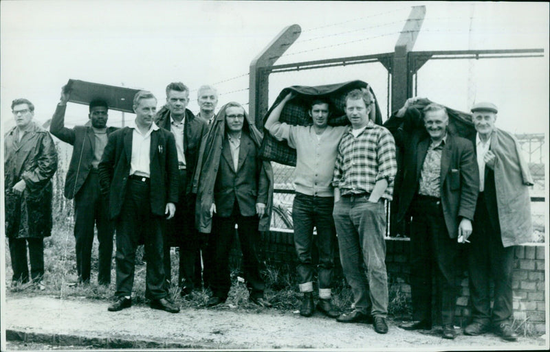 A picket stands in the rain outside a British Road Series depot. - Vintage Photograph