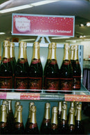 A young person holding a bottle of alcohol and a discount voucher. - Vintage Photograph