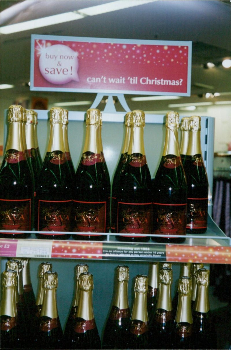 A young person holding a bottle of alcohol and a discount voucher. - Vintage Photograph