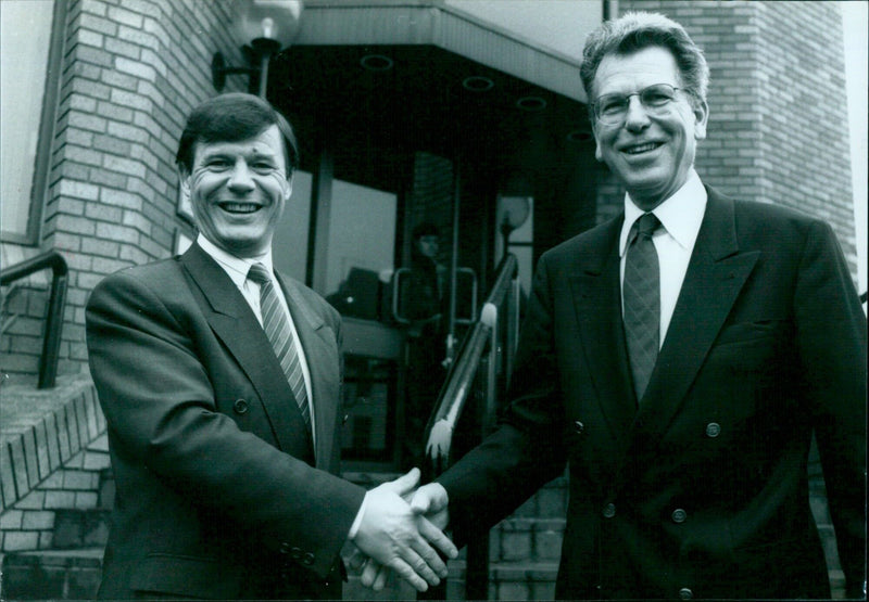 Business partners Clive Bennett and Martin Gutsche greet one another in Oxford, England. - Vintage Photograph