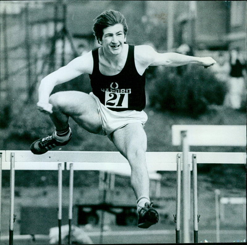 John Ayton of the University Athletics team competes in the 110M Hurdles. - Vintage Photograph