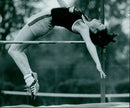 Felicity Waterman of the Omail Pio Mon University athletics team competes in the high jump. - Vintage Photograph