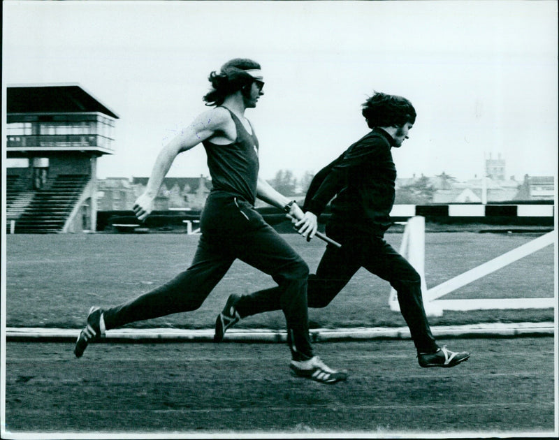 Richard Gyles and Dave Barton practice a baton change during athletics training. - Vintage Photograph