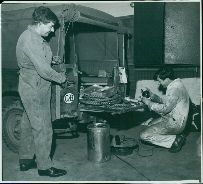 Two volunteers from Witney Technical College prepare a Land Rover for a relief expedition to Florence, Italy. - Vintage Photograph