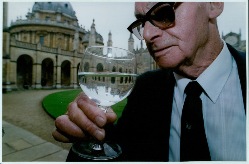 Security guard Ron Gregory takes a break with a glass of lemonade in Oxford's All Souls College. - Vintage Photograph