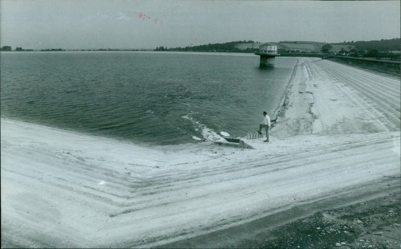 Pete Madden, the Fisheries Manager at Farmoor Reservoir, stands where the water normally would be. - Vintage Photograph