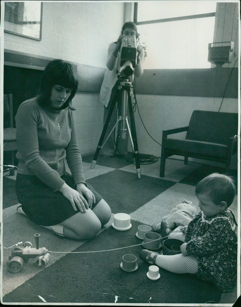 A baby poses for a photograph in a studio setting. - Vintage Photograph