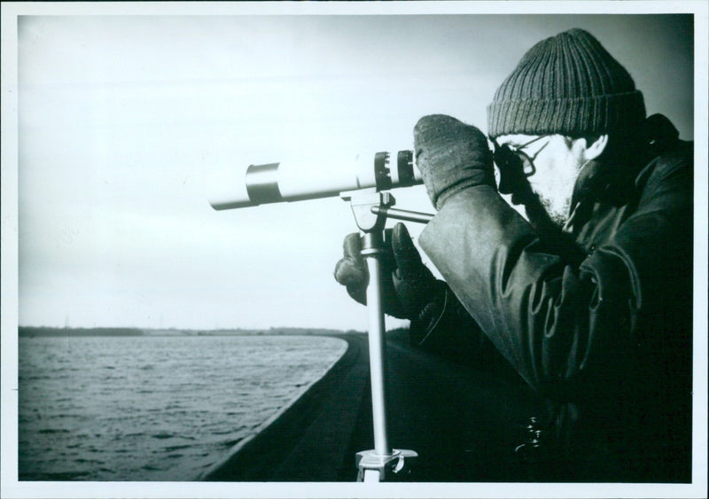 Bird watchers observe birds at the Farmoor reservoir near Oxford, England. - Vintage Photograph