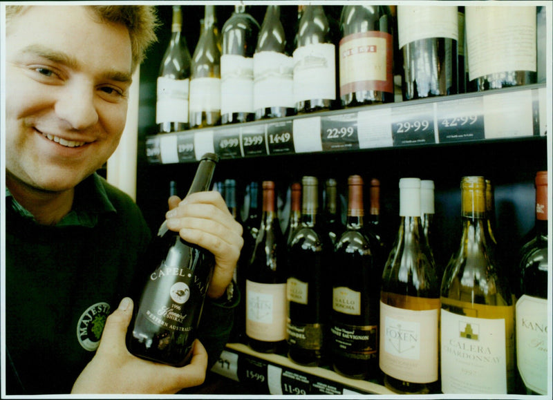 Jon Terry, duty manager at Majestic Wines, displaying an expensive selection of wines. - Vintage Photograph