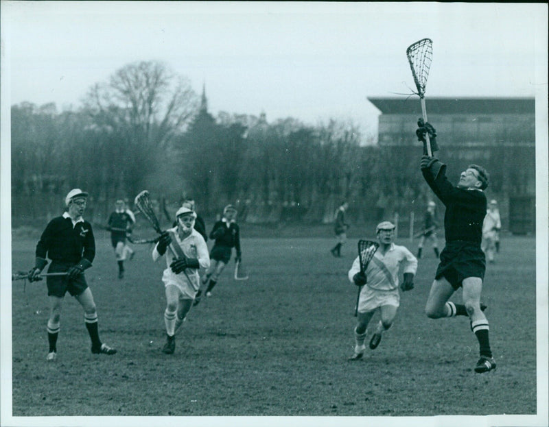 GR Berry leaps to collect the ball during a lacrosse match. - Vintage Photograph
