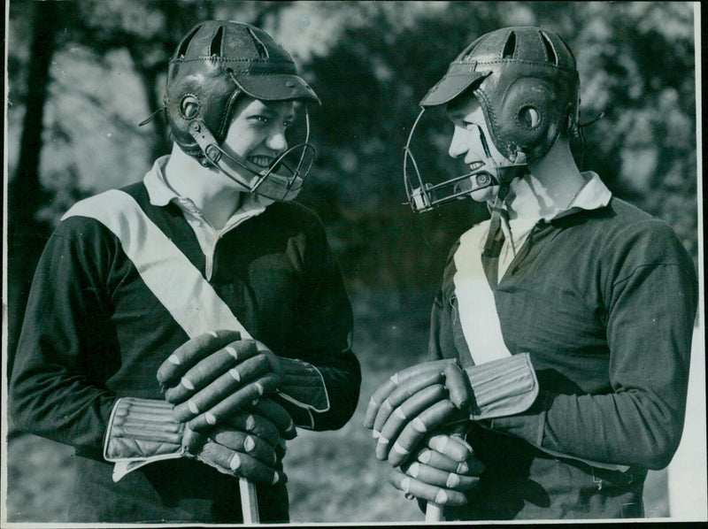 Oxford University lacrosse team members K.G. Hendrik and A.A. Jordan wear protective helmets during their match with Cambridge University. - Vintage Photograph