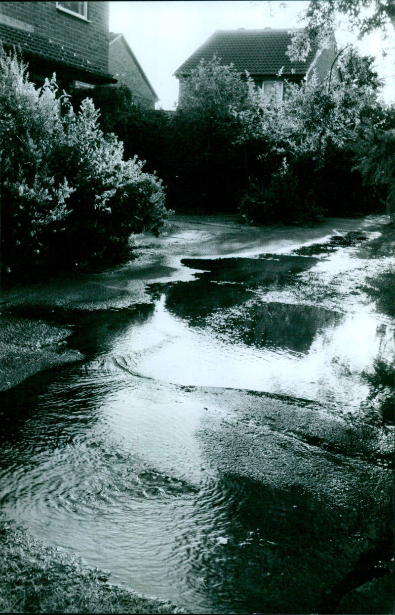 A manhole leaks water from a broken water main in Goodson Walk, Oxford. - Vintage Photograph