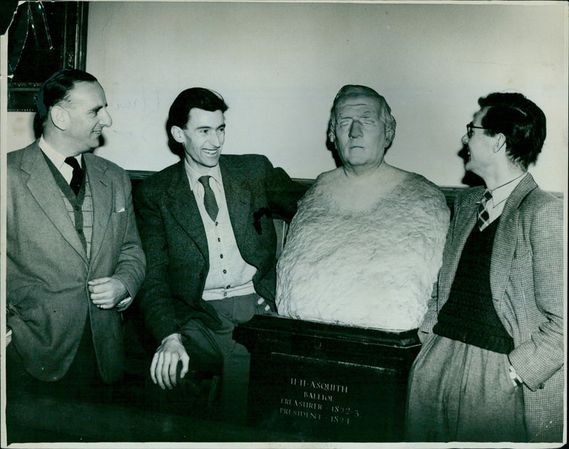 Brian Johnston, Antony Craxton, and Tyrrell Burgess inspect a bust of J.A.F.H. Asquith at the Oxford Union. - Vintage Photograph