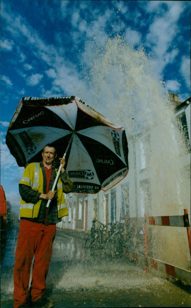 Water mains burst in Bridge Street, forcing residents to wade through the flooding. - Vintage Photograph