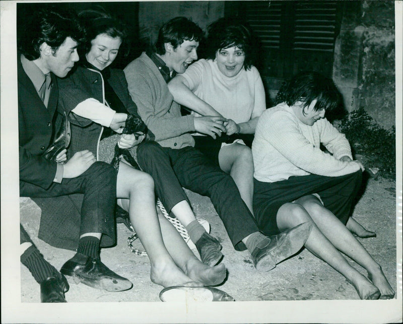 People wringing out their clothes after getting caught in the rain at a May Day celebration - Vintage Photograph