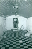 A woman carrying a bundle of firewood on her head in a village in India. - Vintage Photograph