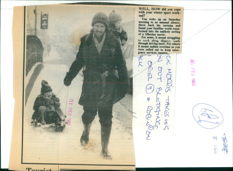 A young boy sledges through the snow in the UK on February 11, 1985. - Vintage Photograph