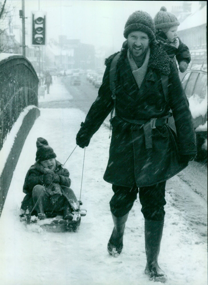 A young boy sledges through the snow in the UK on February 11, 1985. - Vintage Photograph