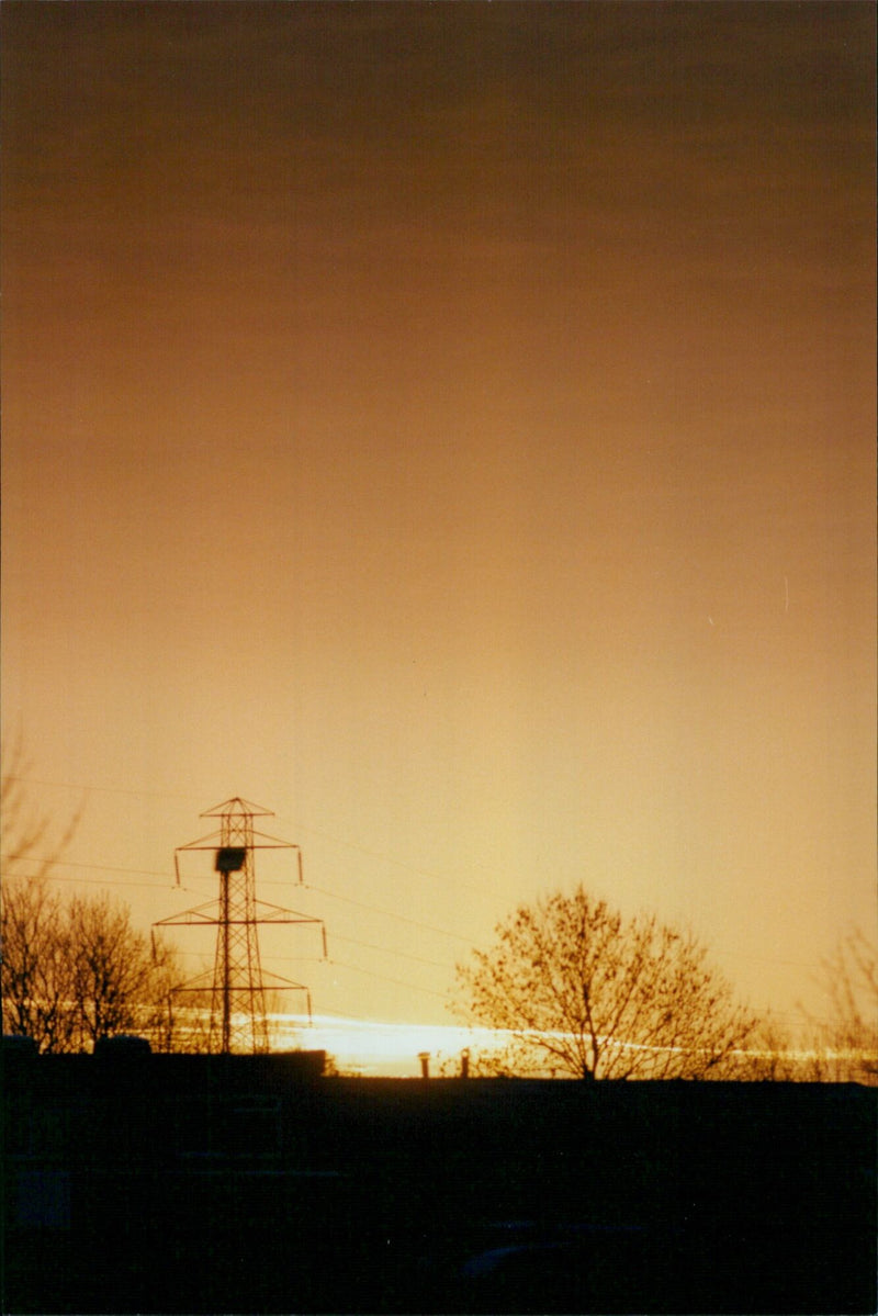 A sunrise illuminates the horizon from a Col N.Desk office. - Vintage Photograph