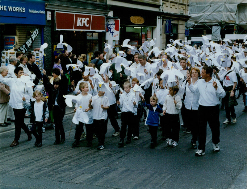 Children and adults take part in a parade at the Mazurs Park in Fingair, Scotland. - Vintage Photograph