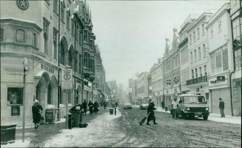 People walking in a snowy Oxford street on a chilly winter day. - Vintage Photograph