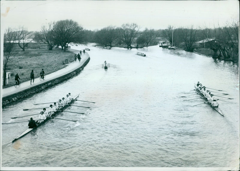 Despite challenging conditions, Division VI boats race through The Gut during the Oxford University Torpids races. - Vintage Photograph