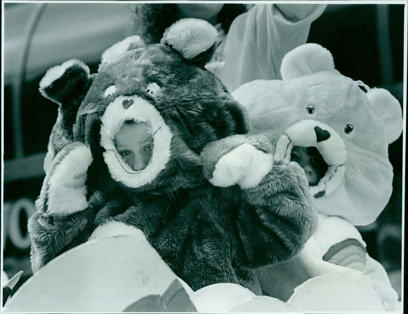 A Care Bear waves to the crowd during a parade. - Vintage Photograph